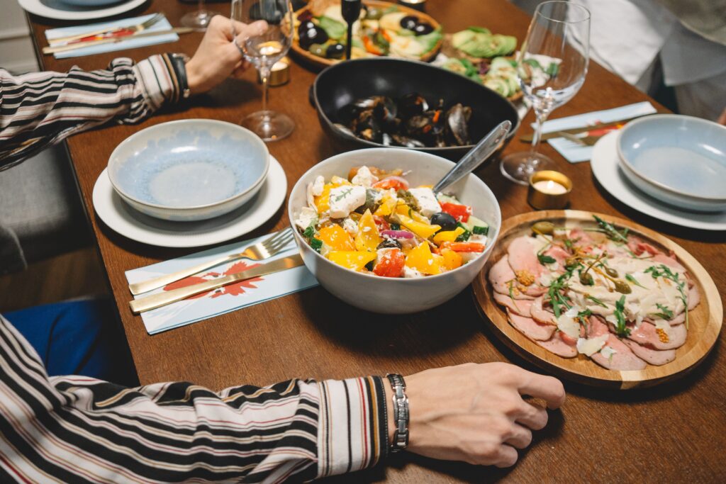 A vibrant dining table setting featuring a colorful salad, seafood, and more.